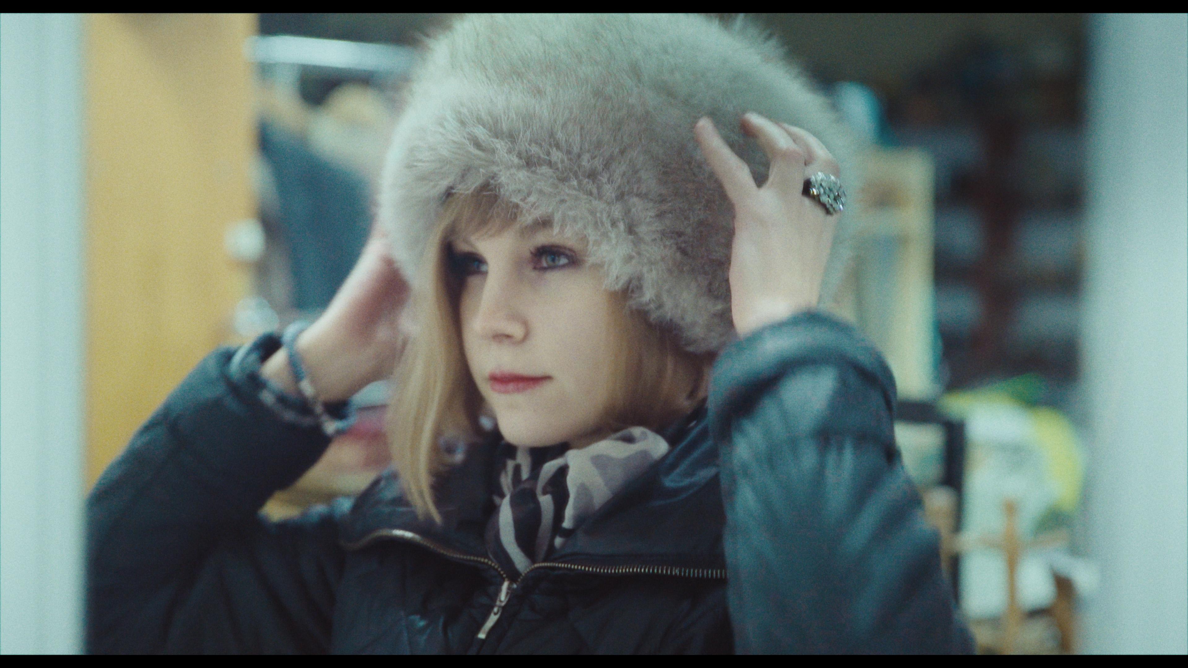 Kobieta poprawiająca zimową czapkę